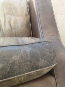 a badly scuffed leather cushion
